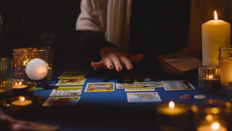 Nahaufnahme-Einer-Frau,-Die-Einem-Mann-Am-Tisch-Bei-Kerzenschein-Tarotkarten-Vorliest-5